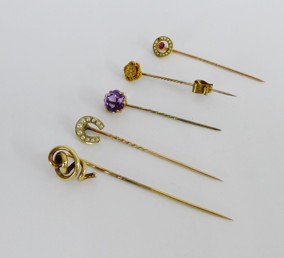 A collection of five tiepins to include a 15 carat gold and diamond set example and a 9 carat gold