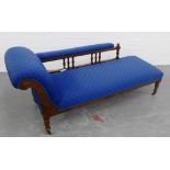 A late 19th / early 20th century carved walnut framed chaise-longue with spindle and padded back,