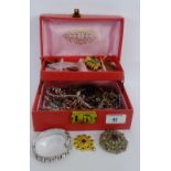 A faux leather jewellery box containing a collection of paste and gilt metal costume jewellery
