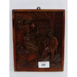 A Black Forest style rectangular carved wall plaque of an interior scene with figures, 18 x 22cm