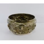 An Eastern white metal bowl with embossed figures and foliage, 17cm diameter