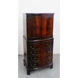 A flame mahogany veneered cocktail / drinks cabinet, the bow front top over a pair of panelled