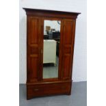 A mahogany wardrobe, the cornice top over a central mirrored door above a single long drawer to