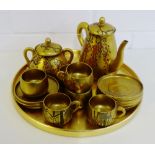 A Japanese gold lacquered tea set comprising six cups, six saucers, sugar bowl, teapot and