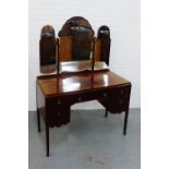 A mahogany triple mirror backed dressing table, with an arrangement of five drawers, on tapering