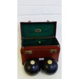 A vintage leather case containing two bowling balls