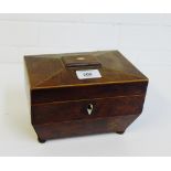 A burr wood sarcophagus tea caddy with two divisions to the interior on four bun feet, 20 x 14cm