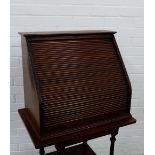 A small mahogany cabinet with tambour sloping front