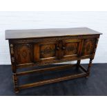 An oak sideboard, the rectangular top over two carved cupboard doors, with baluster turned
