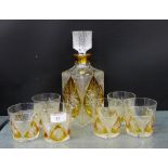 A cut crystal decanter set with amber panels comprising a square decanter and stopper and set of six