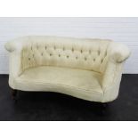 An early 20th century upholstered button back sofa of small proportions, on mahogany supports