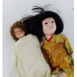 A vintage Japanese doll with bisque head and limbs, dressed in a traditional costume, together