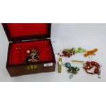 A hardwood jewellery box containing a collection of costume jewellery to include beads and brooches,