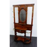 An early 20th century oak hall stand, with central oval mirror back, above a single drawer, with