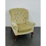 An upholstered button back armchair on cabriole supports