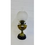 A brass oil lamp on circular hardstone base