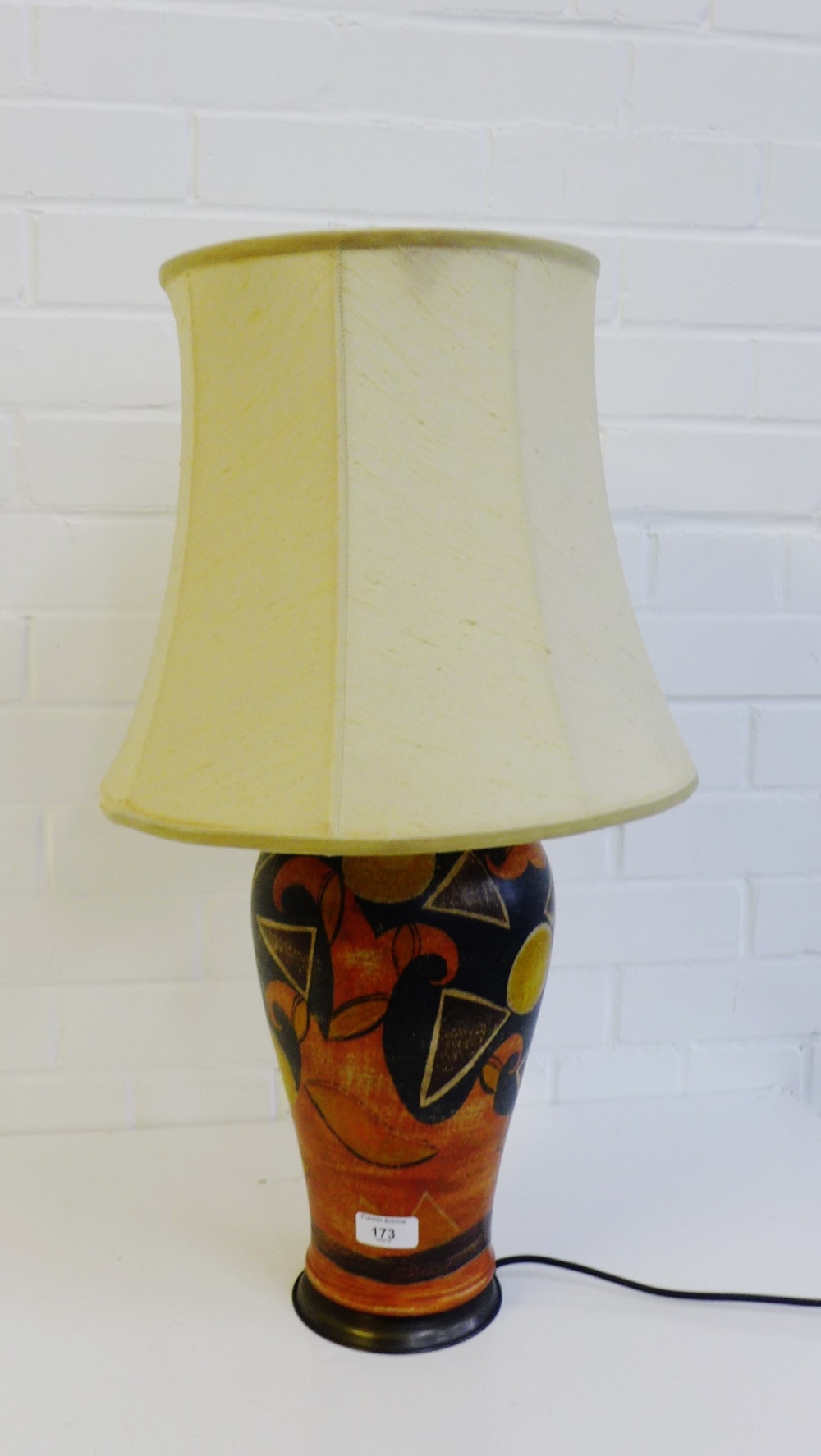 A pottery table lamp base painted with abstract fruit and flowers