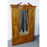 A mahogany and rosewood wardrobe, with an architectural broken pediment top and dentil cornice, over