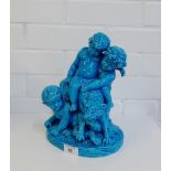 A continental turquoise glazed cherub and panther group on an oval naturalistic base, 28cm high