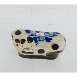 A glazed pottery head rest in the form of a cat