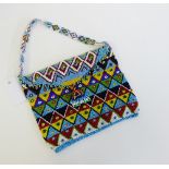 A beaded bag with turquoise, yellow, red and green geometric pattern, 23cm wide