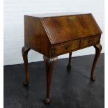 A walnut bureau, with pull out slides and two frieze drawers on acanthus carved cabriole supports