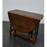 An oak gateleg table with oval top on barley twist supports, 74 x 91cm