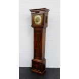 An oak cased Grandmother's clock, with the cornice top over a brass dial with silvered chapter