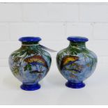 A pair of early 20th century art pottery vases with hand painted pattern of fish swimming amongst