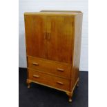 An early 20th century oak ledgeback cabinet with two cupboard doors over two long drawers on