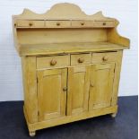 A pine dresser with four drawers to the ledgeback, above three drawers and two cupboard doors to the