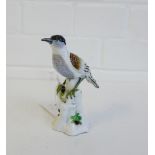 A 19th century Meissen style porcelain bird modelled perched upon a tree stump, with blue crossed