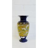 A Doulton baluster vase with floral chine panel to the body against a blue ground with impressed