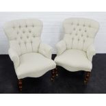 A pair of grey upholstered button back armchairs on turned mahogany supports with brass caps and