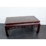 A Chinese hardwood low table, the rectangular top over a stylised frieze, 44 x 102cm