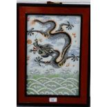 A rectangular Chinese ceramic plaque with a Dragon chasing the Pearl of Wisdom pattern, framed, 26 x