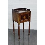 A 19th century mahogany pot cupboard with three quarter gallery, with urn paterae to the door, on