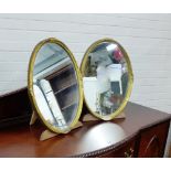 A pair of oval gilt framed dressing mirrors, with easel strut backs, (One wormed) 50cm (2) From