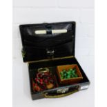 A green leather jewellery box containing vintage coloured beads, together with two vintage