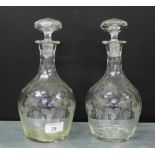 A pair of fruit and vine etched decanter and stoppers, 26cm high