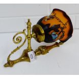 A brass light fitting with a Galle style orange and black glass shade