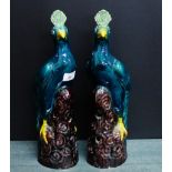A pair of green glazed bird figures each modelled perched upon a pierced rocky mound (damages), 37cm