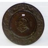 A circular embossed bronzed metal wall plaque, 63cm diameter