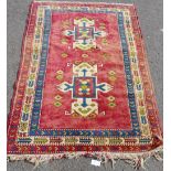 A Turkish rug the red field with central geometric motifs within multiple borders 204 x 134cm