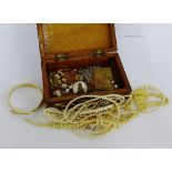 An inlaid wooden box containing a collection of faux pearls, carved bone necklace, early 20th
