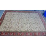 A foliate patterned carpet, the cream field within a red flowerhead border, 550 x 375cm