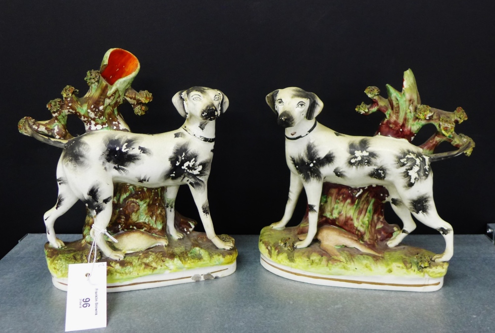A pair of 19th century Staffordshire black and white hound spill vases on oval bases, 25cm high, (2)
