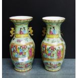 A pair of Chinese Celadon green glazed baluster vases with mythical beast handles and painted with