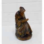 A figure of a Monk, modelled seating reading, 18cm high