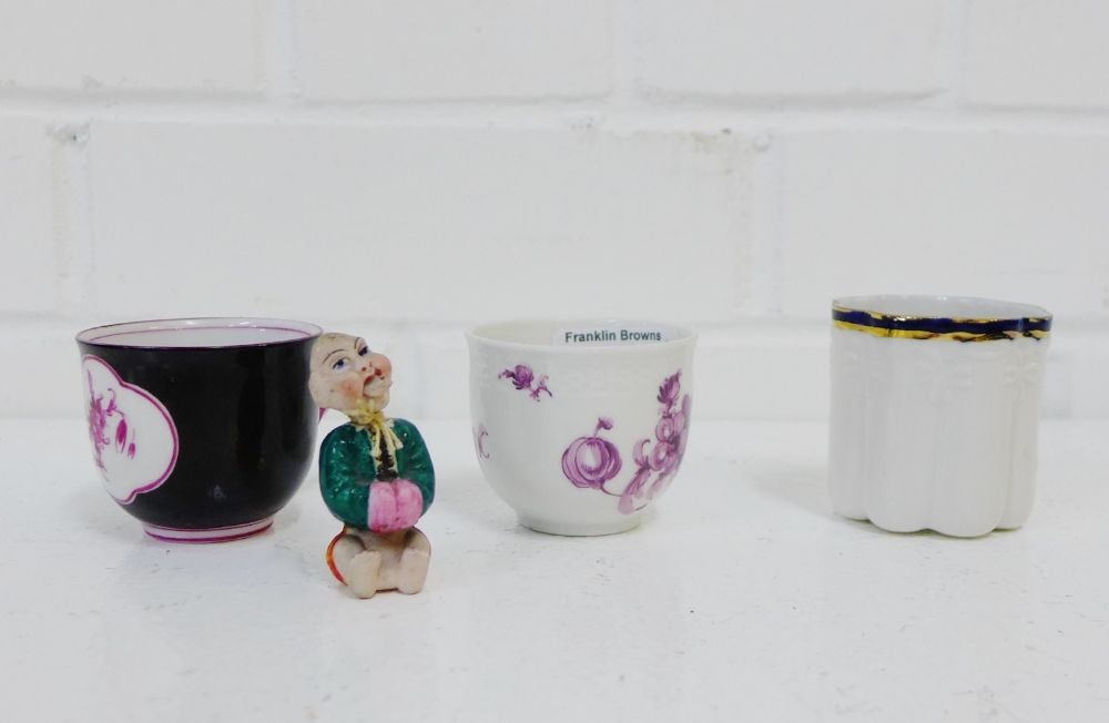 A group of three small porcelain demi tasse cups, together with a bisque nodding head figure, (4)
